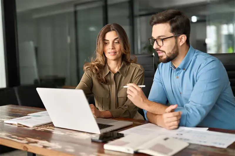 Man and woman collaborating behind a laptop
