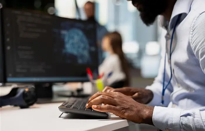 Close-up of a professional using a laptop with futuristic holographic data overlays to demonstrate GenAI in a Box capabilities