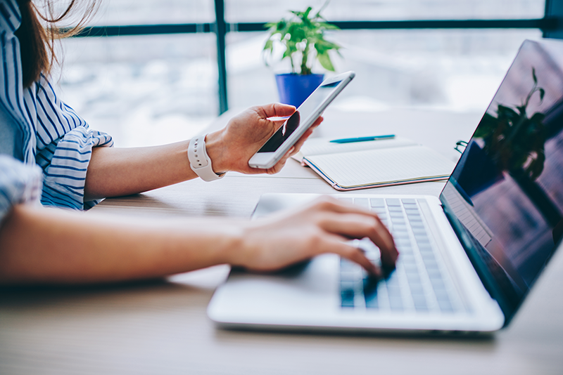Woman searching things on her computer and her phone