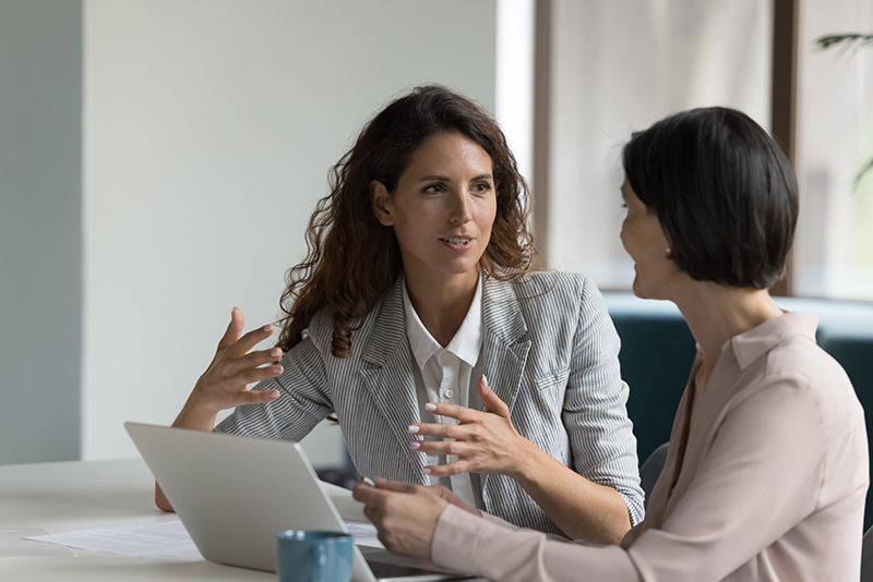 Two women discussing in front of a computer