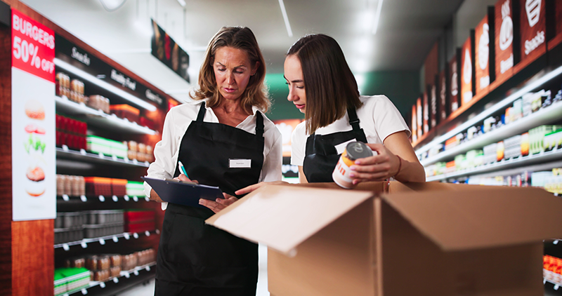 Two female shop workers discussing stock