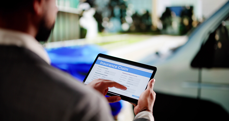 insurance adjuster assessing vehicle damage following a car accident 